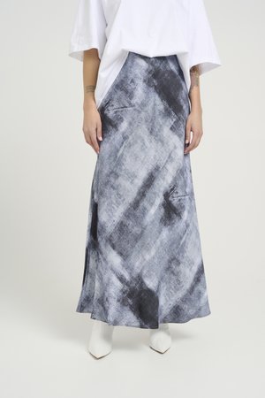 Long, flowy skirt in gray and black abstract pattern, made of lightweight fabric. Features a side slit and pairs with white pointed toe boots.