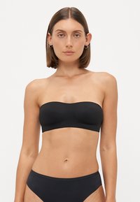 Black strapless bikini top, smooth fabric, elastic material, seamless design, with matching black bikini bottoms, minimalist style.