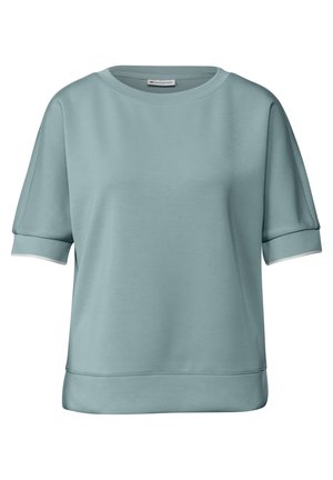 Lyseblå kortærmet sweatshirt lavet af blødt materiale med rund hals og hvid kant på ærmerne og taljen. Glat tekstur.