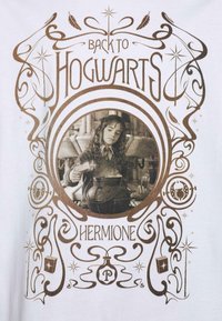 Biała koszulka z graficznym nadrukiem "Z POWROTEM DO HOGWARTS" oraz wizerunkiem dziewczyny z brązowymi akcentami i ozdobnymi spiralami wokół niej.