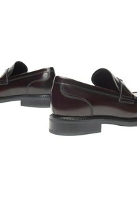 Mocassini in pelle bordeaux dal design elegante, con punta arrotondata, cuciture decorative e suola in gomma texturizzata bassa.