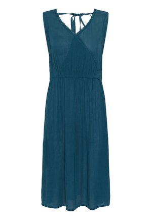 Mėlynos spalvos suknelė be rankovių, su V formos dekoltė, apvyniojimo dizainu, susiraukšlėjusiu liemeniu ir tekstūruota medžiaga. Turi kaklo uždarymą ir banguotus kraštus.