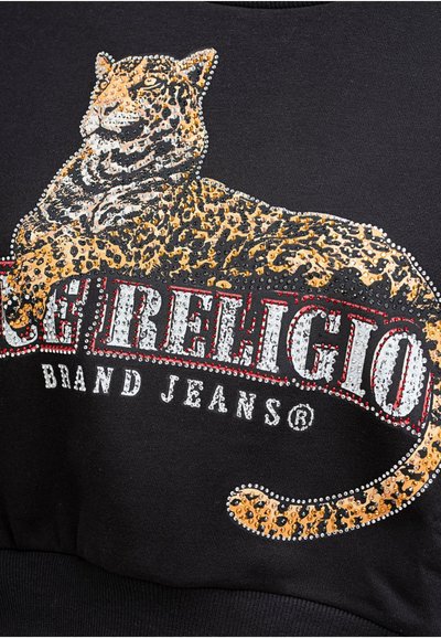 Sweatshirt noir avec un graphisme de léopard orné de strass, et un texte en blanc et rouge indiquant "Rock Revival Brand Jeans."