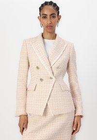 Blazer de dois botões em tecido de tweed pastel texturizado com um acento branco, apresentando Ferragens douradas e dois bolsos frontais.