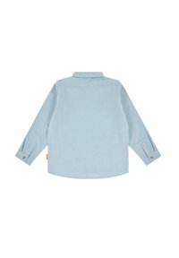 Camicia azzurro chiaro a maniche lunghe con colletto, polsini abbottonati, orlo curvo e un'etichetta di lato, realizzata in un tessuto testurizzato.
