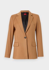 Blazer marrone con rever a punta, chiusura con un solo bottone e due tasche frontali. Realizzato in tessuto liscio, con una fodera interna nera.