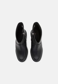 Botas negras hasta el tobillo hechas de cuero suave, con cremallera lateral, punta redonda y un interior acolchado para mayor comodidad.