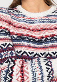 Pull en maille à motifs avec des rayures horizontales rouges, bleu marine et blanches, agrémenté de dessins géométriques et d'un col rond côtelé.