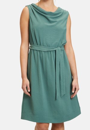 Mouwloze teal knielange jurk met een gedrapeerde halslijn en een bijpassende stoffen riem gestrikt in de taille.