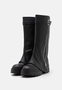 Botas de cuero negro hasta la rodilla con cremallera lateral, detalle de hebilla, puntera redonda y suela gruesa y texturizada. Acabado suave en general.