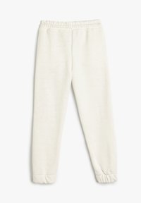 Pantalones jogger blancos y suaves con cintura elástica, puños ajustados y tela lisa y texturizada. Sin estampados ni patrones visibles.