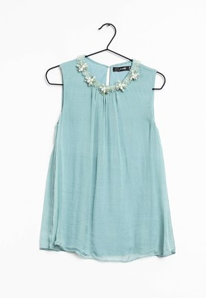 Light blue sleeveless blouse with pleats, embellished white and green floral collar, smooth texture, and keyhole back detail.