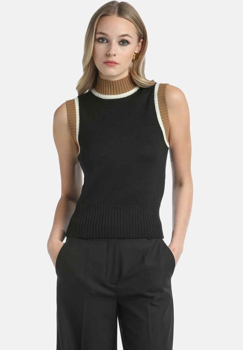 Juodas be rankovių megztinis su aukštu kaklu, su briaunota apačia, kontrastuojančiais tan pečiais ir baltais apvadais. Medžiaga atrodo, kad yra megzta ir tekstūruota.