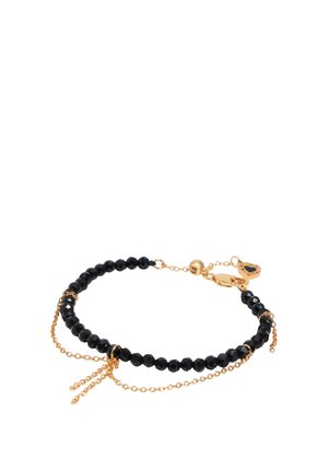 Delikatna bransoletka z fasetowanymi czarnymi koralikami, złotymi akcentami łańcuszka i zapięciem w kształcie złotego serca na białym tle.