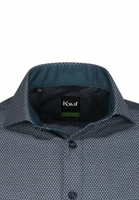 Camicia button-up di colore blu scuro con motivo geometrico. Presenta un colletto foderato in teal a contrasto e bottoni neri. L'etichetta della taglia riporta "38."