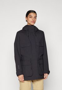 Zwarte hooded jack met een ritssluiting aan de voorkant, twee borstzakken en twee lagere cargozakken. Beschikt over verstelbare trekkoorden en een gladde textuur.
