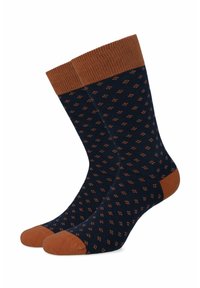 Granatowe skarpetki z małym pomarańczowym wzorem, z prążkowanym brązowym mankietem, piętą i akcentami palców, wykonane z miękkiego, elastycznego materiału.