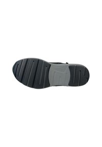 Suela de zapato negra con un diseño texturizado, que presenta surcos y crestas para mayor tracción. La entresuela es gris con un acabado suave y un detalle de logo.