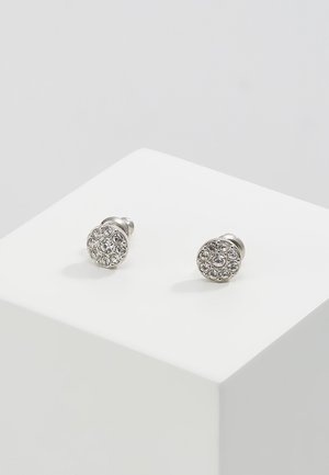 Boucles d'oreilles à clous ronds en argent avec une pierre centrale entourée de petits cristaux clairs, présentées sur une surface blanche.