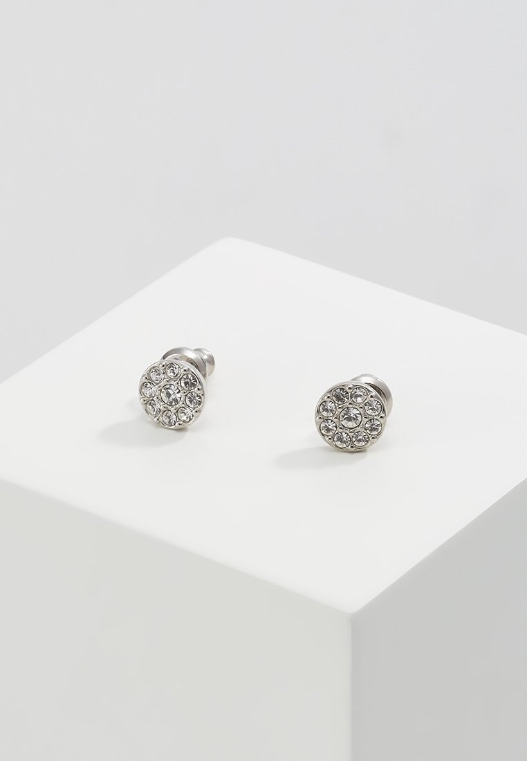 Boucles d'oreilles à clous ronds en argent avec une pierre centrale entourée de petits cristaux clairs, présentées sur une surface blanche.