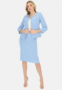 Jasnoniebieska marynarka w tweed z rękawami o długości trzech czwartych i zapięciem na guziki z przodu, w połączeniu z dopasowaną spódnicą o kroju ołówkowym, gładka faktura.