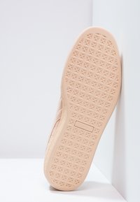 Ljusbeige sneaker sula med ett texturerat diamantmönster, försedd med en upphöjd logotyp. Släta kanter som smalnar av mot tån.