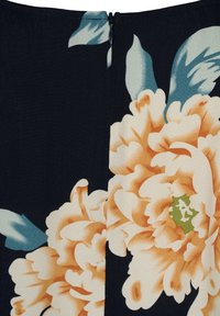 Detail eines Blumenkleides mit einem dunklen Hintergrund, großen Pfirsich- und Cremetönen der Pfingstrosen, kontrastierenden grünen Blättern und einem vertikalen Reißverschluss.