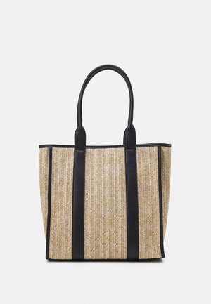 Sac cabas tissé beige avec deux longues anses noires et une bordure verticale noire sur fond uni.
