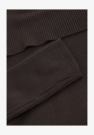 Ruskea resorikangas, jossa on pystysuuntaisia linjoja muistuttava rakenne. Ylhäällä on koukkureunainen yksityiskohta ja alapuolella sileä, tasainen osa.