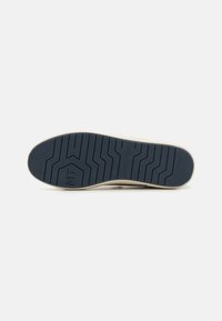 Semelle de sneaker en caoutchouc texturé marine, avec un motif de semelle en vagues. Comprend le logo "MARCO TOZZI" et la taille "42" en relief.