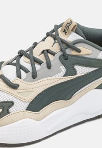 Baskets avec une tige en mesh et en daim de couleur blanche, verte et beige. Présentent des accents texturés et un col rembourré. Lacets en vert foncé.