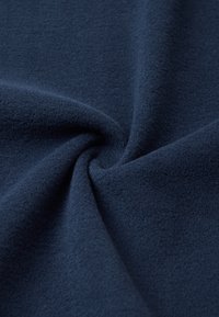 Tessuto in pile blu navy con una superficie morbida e texture, che presenta una caduta liscia e flessibile, ideale per abbigliamento caldo o coperte.