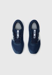 Paire de chaussures de sport New Balance 578 bleu marine avec logo blanc et semelles blanches, vues de dessus sur fond blanc.