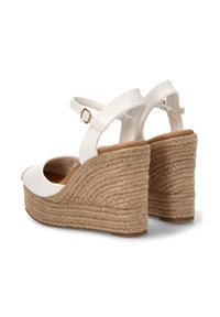 Sandalias de cuña blancas con tiras en el tobillo y cierres de hebilla, con tacones de cuerda tejida texturizada y plantillas acolchadas color canela.