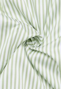 Tessuto di cotone con un motivo di strisce verdi e bianche alternate. La texture appare liscia e morbida, con una leggera lucentezza.