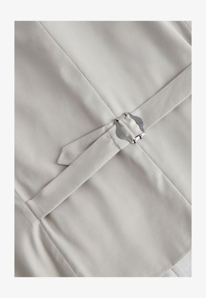 Jasno-beżowa tkanina o gładkiej fakturze, z krzyżującym się paskiem zabezpieczonym srebrną metalową klamrą i płaskimi szwami.