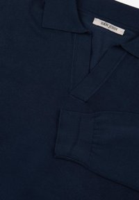 Polo shirt lavorato a maglia blu navy con mezza pattina, colletto a coste e polsini. Texture liscia e finitura pulita. Etichetta con la scritta "DAN JOHN."