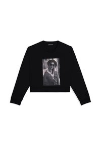 Felpa nera a maniche lunghe con una grande stampa grafica in bianco e nero con il testo "MOTION IS A THING" e una modella che indossa occhiali da sole.