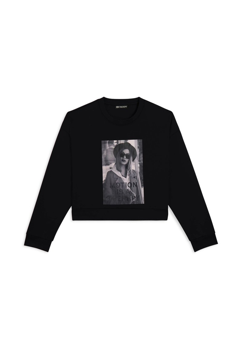 Felpa nera a maniche lunghe con una grande stampa grafica in bianco e nero con il testo "MOTION IS A THING" e una modella che indossa occhiali da sole.