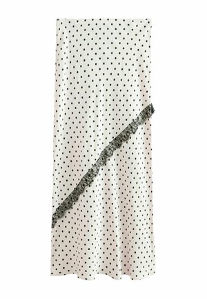 Jupe blanche à pois noirs avec une bordure en dentelle noire diagonale à l'avant.