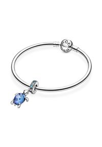 Bracciale in argento con chiusura rotonda. Presenta un ciondolo a forma di tartaruga blu e un ciondolo circolare con accenti azzurri. Finitura liscia e lucida.