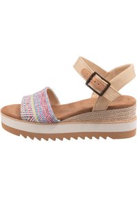 Multicolored fabric wedge sandal with a patterned upper, beige ankle strap, and white rubber sole featuring a textured, ridged design.