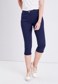Marineblauwe capri-broeken van rekbare katoen met een slanke pasvorm, voorzien van een knoopsluiting, zijzakken en een zoom die halverwege de kuit eindigt.