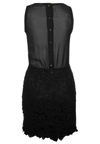 Vestito nero con un top trasparente e chiusura a bottoni, e una gonna in tessuto di pizzo con motivi floreali e orlo scallop.