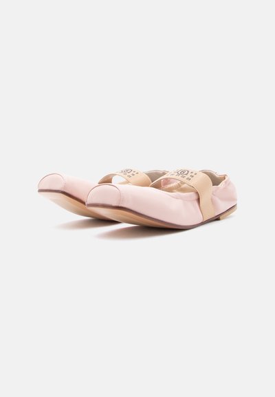 Mehko roza baletne balerinke z bež elastičnimi trakovi, na katerih so označene velikosti, prikazane vzporedno na belem ozadju.