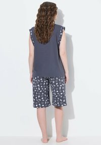 Dunkelgraues Schlafoutfit mit einem ärmellosen Top und bedruckten Shorts. Das Top hat eine einfarbige Gestaltung, während die Shorts ein weißes, maritimes Design zeigen.
