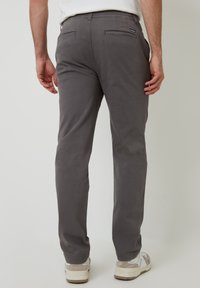 Grijze katoenen broek met een rechte pasvorm, voorzien van twee achterzakken en subtiele branding. Zachte textuur en casual stijl.