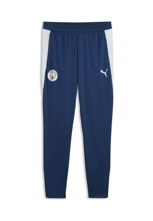 Mørkeblå sportbukser med lysegrå sidepaneler, med Manchester City-logo på venstre ben og hvid Puma-logo på højre ben.