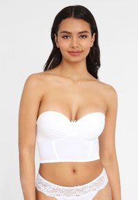 White strapless bra with padded cups, lace accents, and a smooth finish. Features a structured silhouette and decorative bow at the center.