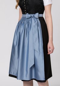 Dirndl mit einem Mieder aus schwarzer floraler Spitze, ergänzt durch eine blaue Satin-Schürze und ein passendes Band, das um die Taille gebunden ist.